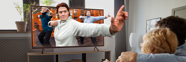 Zwei Personen sitzen auf der Couch und schauen TV